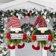 国境を越えたクリスマスのドワーフは前のドアを飾ってクリスマスのペンダントの花輪の室内の壁を飾ってクリスマスの花輪を飾っています。