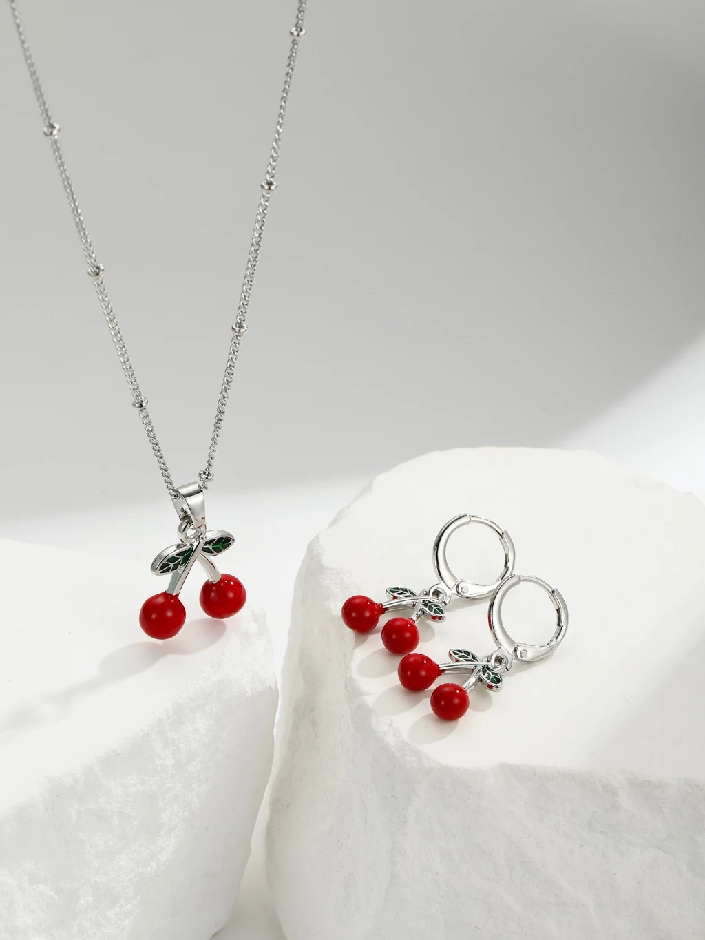 Explosiones transfronterizas coloridas cereza roja pintada a mano goteo de frutas series de joyería simple colgante de viento conjunto de aretes collar