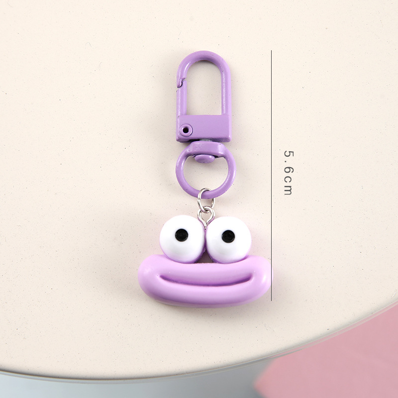 かわいいアニメの大きな口のキーホルダーは学生のカバンを飾っています。