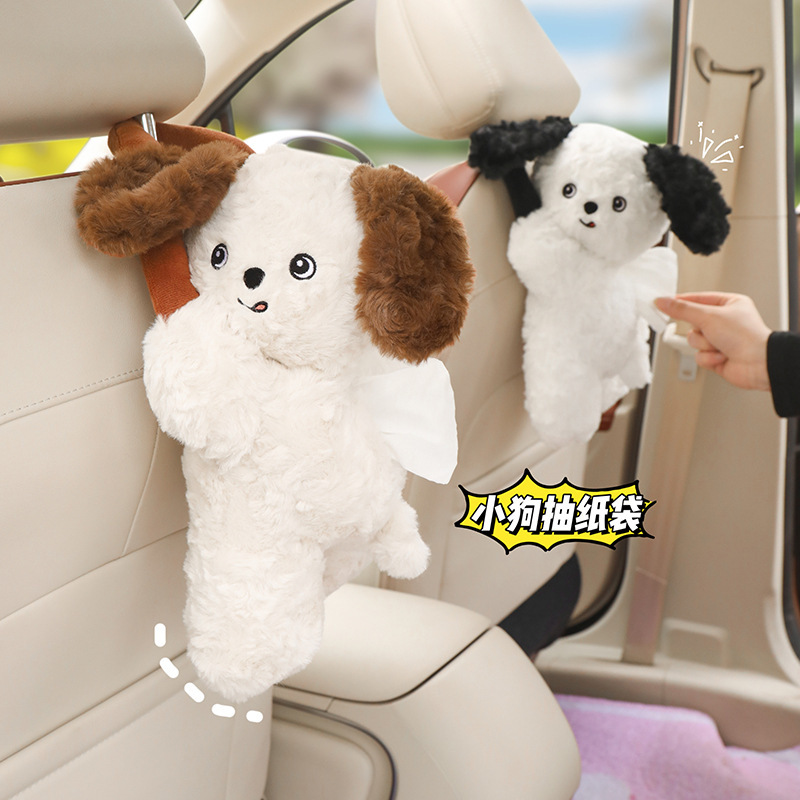 車のティッシュの箱のかわいい子犬のぬいぐるみがうつぶせになります。|undefined