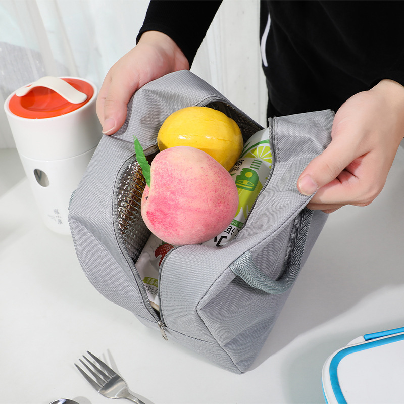 保温弁当箱は昼食バッグを持って外出して食事保温バッグを持ってアルミ箔を厚くしてシンプルな風保温弁当箱袋を持っている|undefined