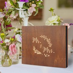 結婚式のメッセージ帳は薄いウェディングドレスの本の記念帳に署名します。