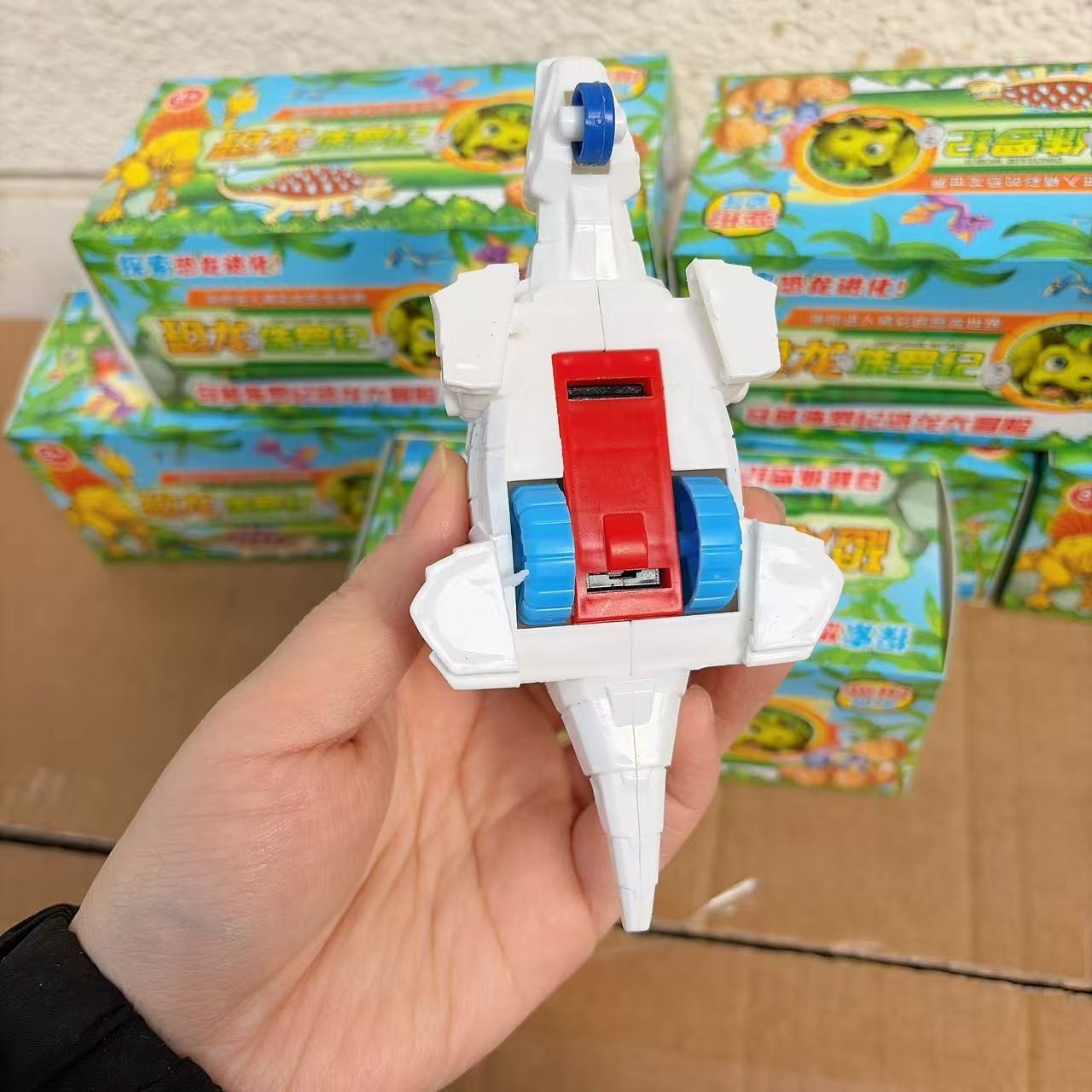 Juguetes de caja de colores para niños dinosaurios patineta deformación modelo de juguetes para niños 2 yuanes al por mayor
