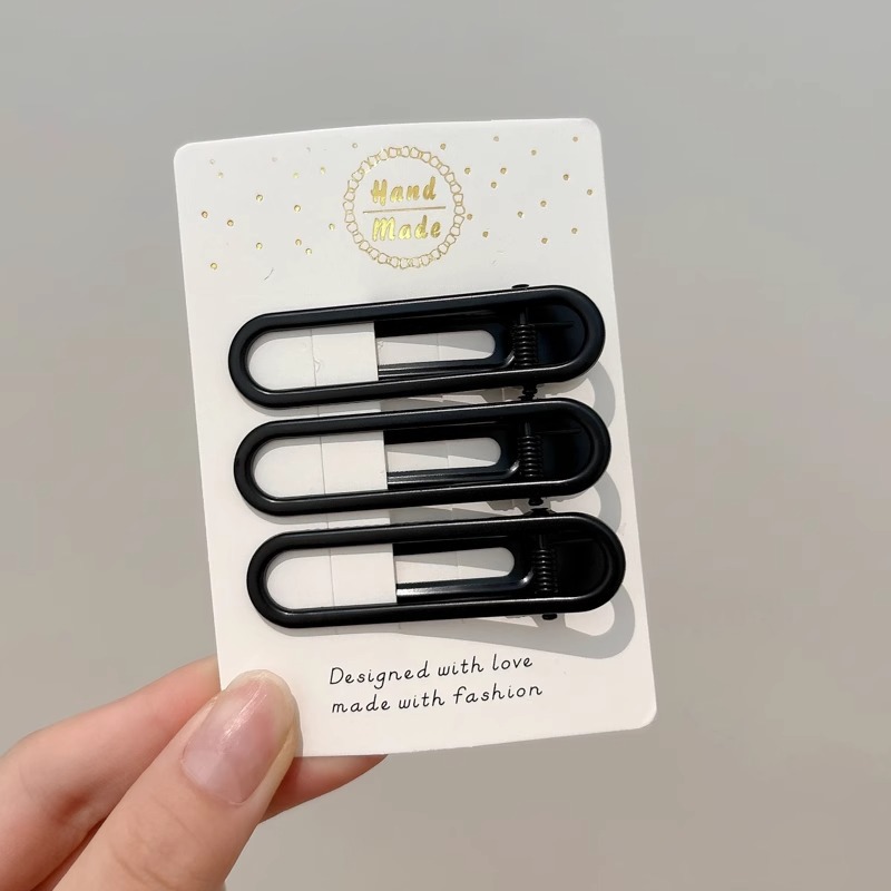 Clipper de cabello de metal negro de alto nivel, frente lateral de la mujer, cabello roto, boca de pato, tocado, clipper para el cabello