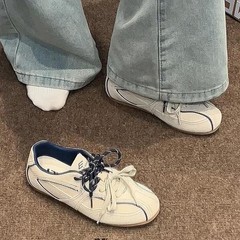 牛革版の平底の中で高くなっています。レトロな阿甘靴の丸いカジュアルシューズの女性は徳訓靴の運動靴を持っています。