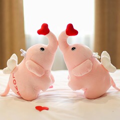 赤ちゃんの赤ちゃんのペアの象は枕のぬいぐるみの人形を抱いて結婚します。