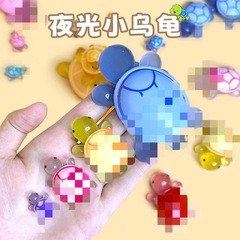 小さいカメは夜光のカラーの小さいカメのおもちゃにぶつかります。