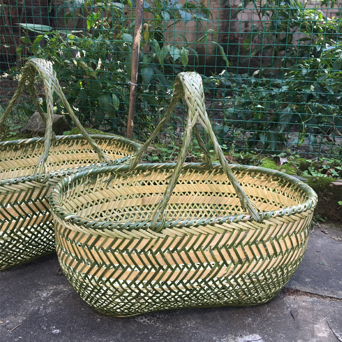 竹編みの竹かごを手に持って野菜かごを買う手作りの竹かごの果物かごの卵かごの台所収納かごの家庭用買い物かご|undefined