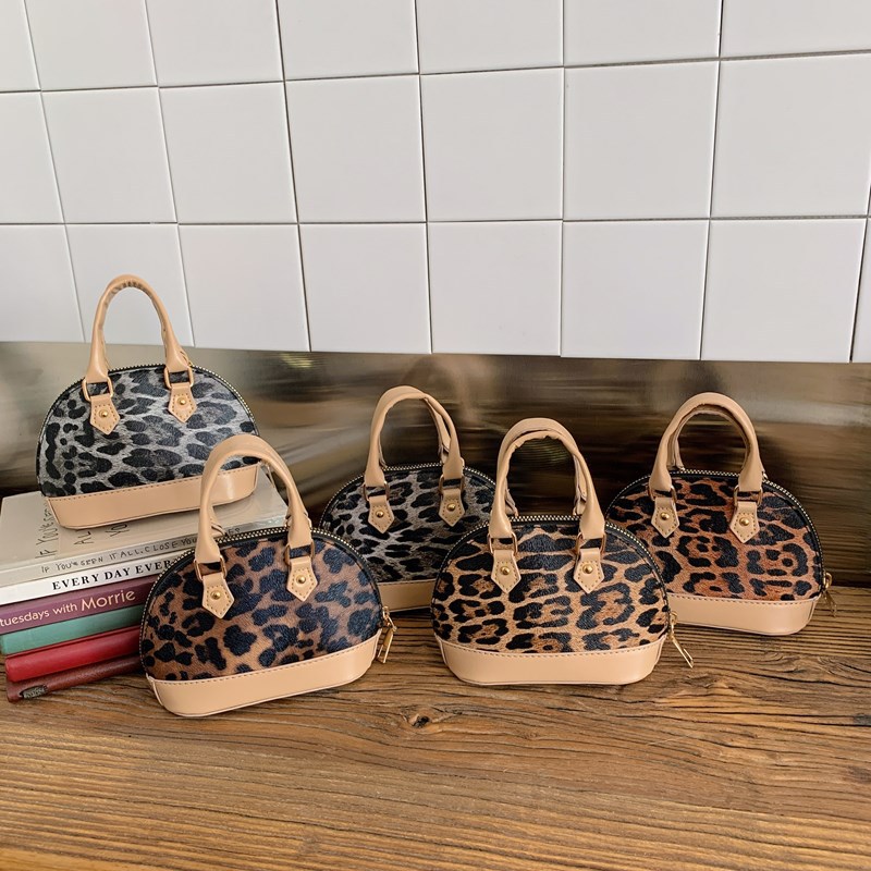 Moda cool leopardo mochila para hombres y mujeres, bolso de hombro compacto mini bebé bolso de cadena 2025 nuevo bolso de conchas para niños