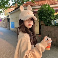 子羊のぬいぐるみ野球帽の女性は秋冬のファッションが顔を見せています。