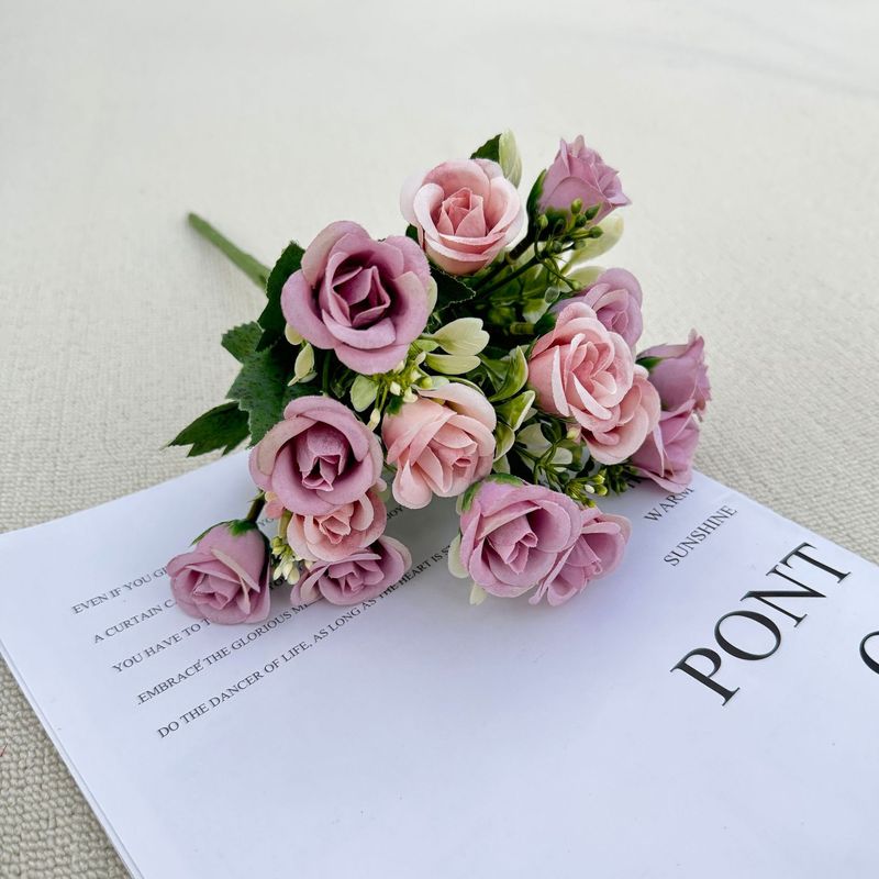 模造花ミニバラは花を手にして家にいる結婚式の室内客間の装飾に造花を飾っている|undefined