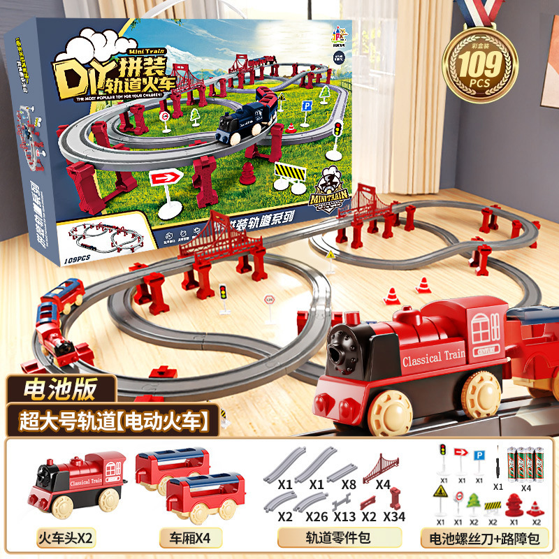 国境を越えた電気高速鉄道の電車は軌道を持っている男の女の子が模型を組んで車のおもちゃの誕生日プレゼントをシミュレートした