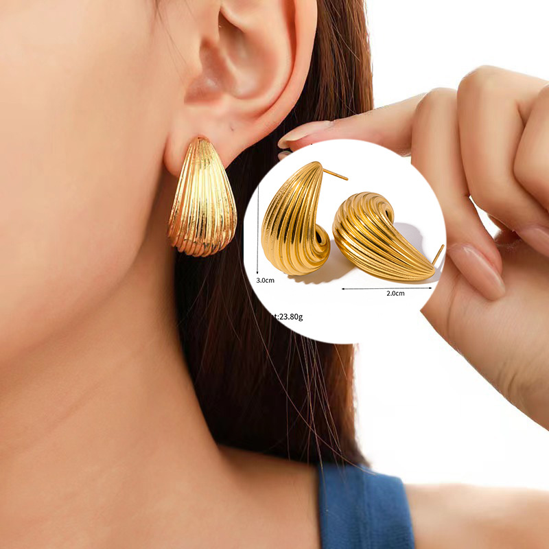 Comercio exterior Europa y Estados Unidos rayas huecas de alta calidad pernos de acero de titanio chapados en oro 18K composto textura pendientes esféricos para mujeres