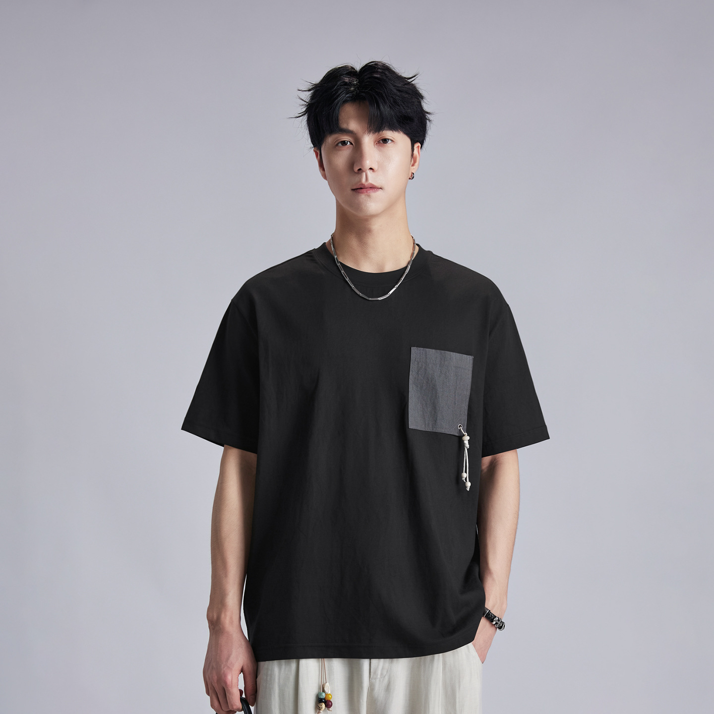 Áo thun nam cổ tròn tay ngắn chất liệu cotton thoáng mát, form rộng thả vai, túi đắp phối màu đính cườm — đen