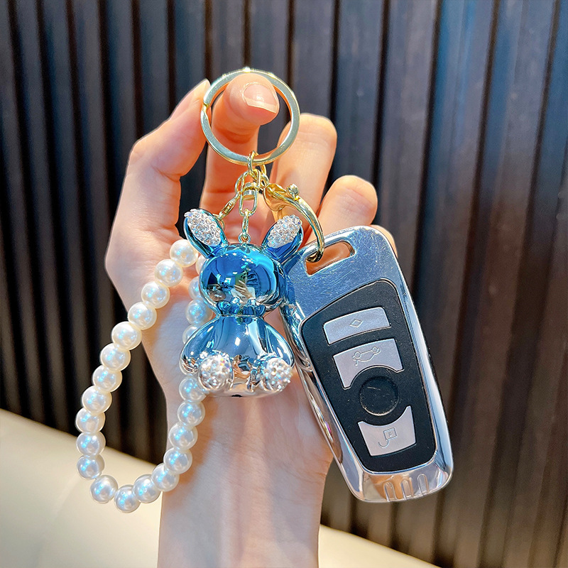 Cadena de perlas con incrustaciones de diamantes llavero de conejo bolso de muñeca colorido colgante llavero de coche máquina de muñecas regalo al por mayor
