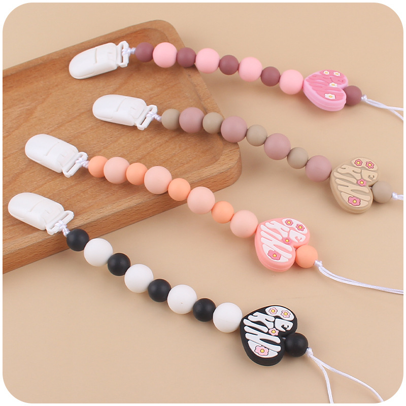 Nuevo bebé suministros de dibujos animados amor mordedor creativo DIY bebé mordedura de silicona Cadena de pezón cadena anti-caída