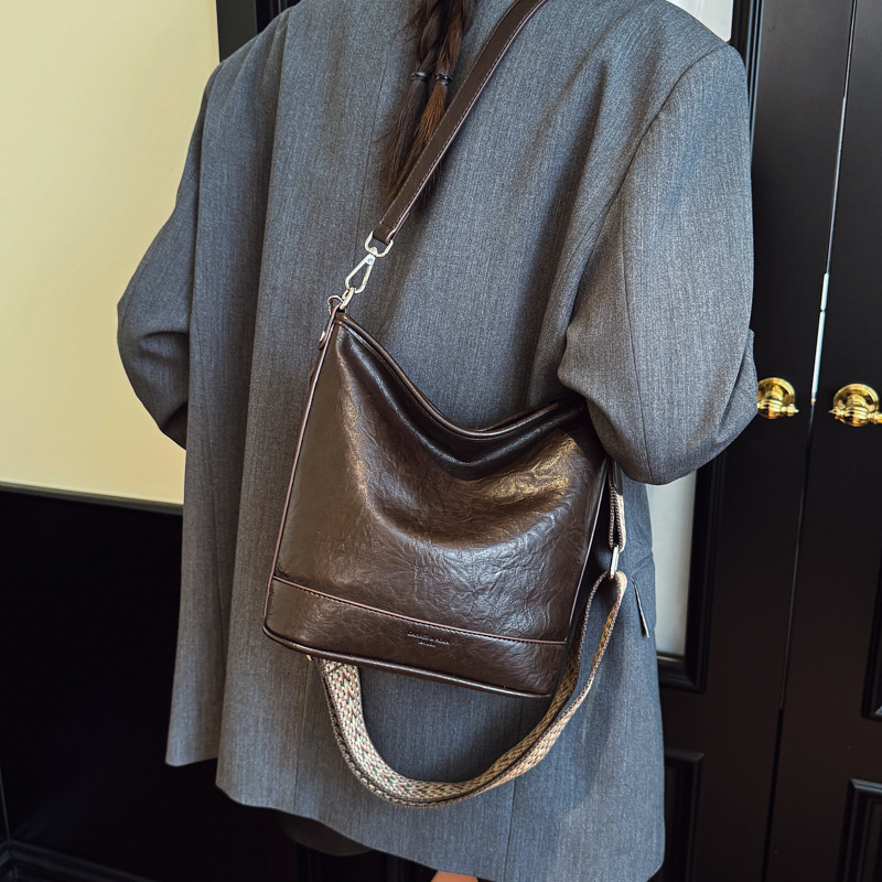 Bolsa de cubo de gran capacidad de cara suave coreana para mujeres otoño / invierno 2025, nueva moda simple bolso de hombro retro bolso de mochila