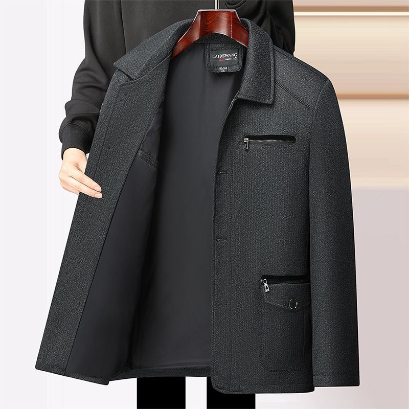 秋冬の中高年のメンズとベルベットのコートのお父さんはビジネス服の中年の男性の厚いジャケットの上着を襟を返します。