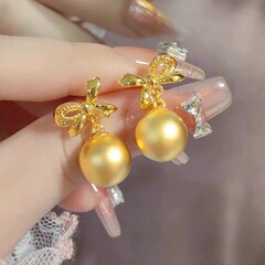 金色の蝶結びの糸引きボールのピアスの女性は逃げています。