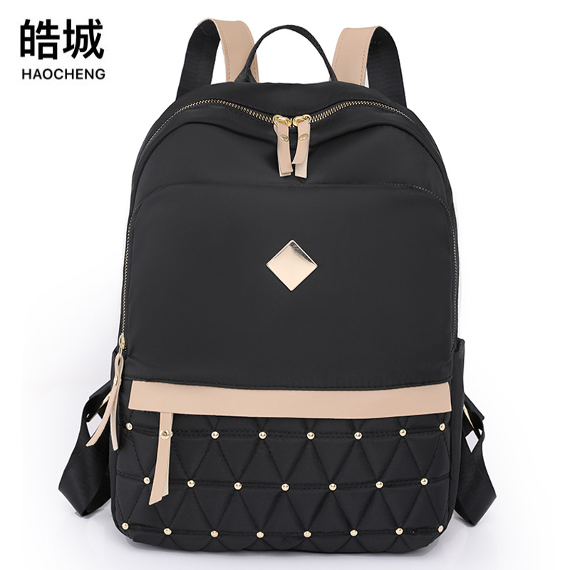 El fabricante emitió 2023 nuevas mochilas de nailon para mujer coreana, bordado de moda, remaches, mochila de viaje, mochila escolar para mujer