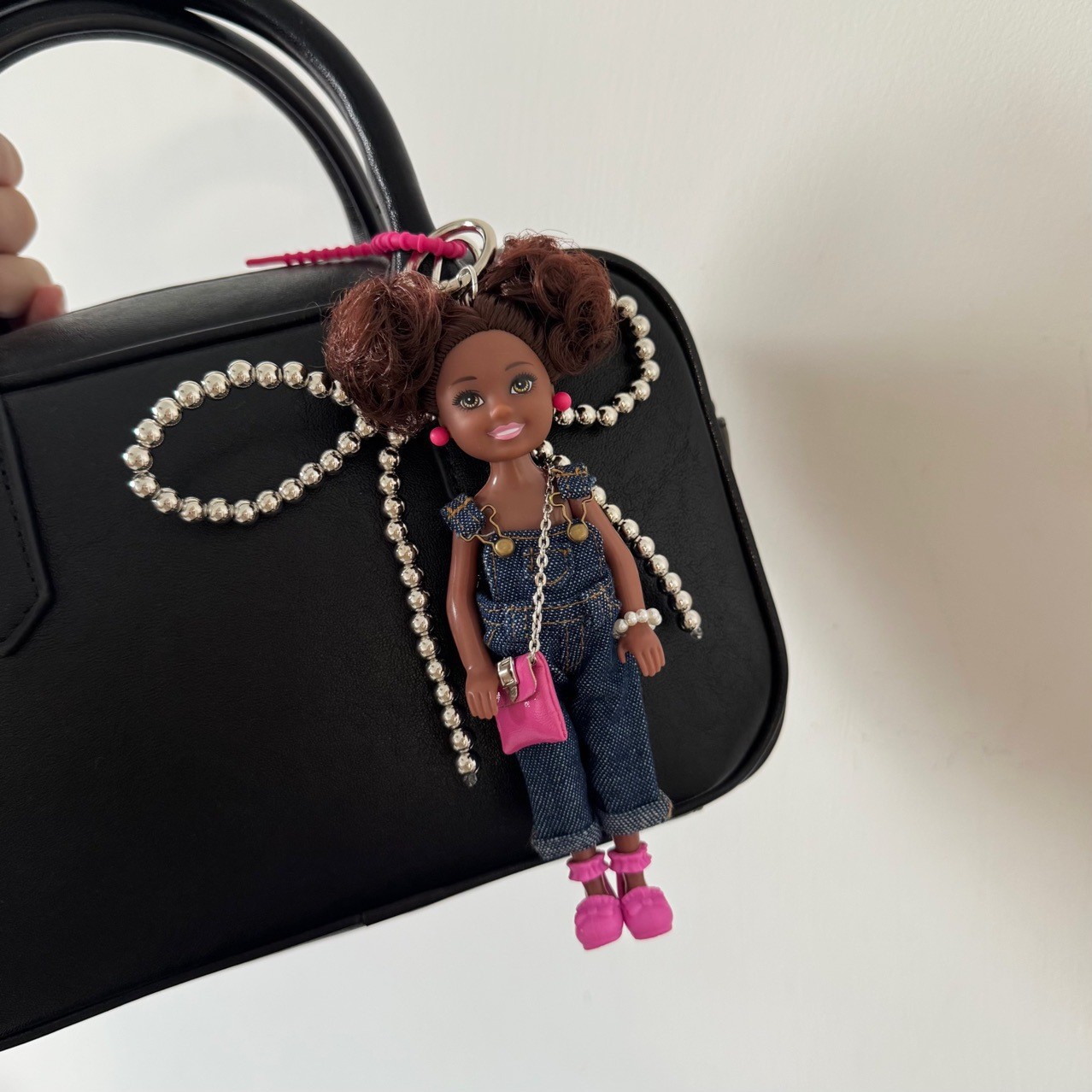 로즈 핑크 신발과 어두운 작업복 아기