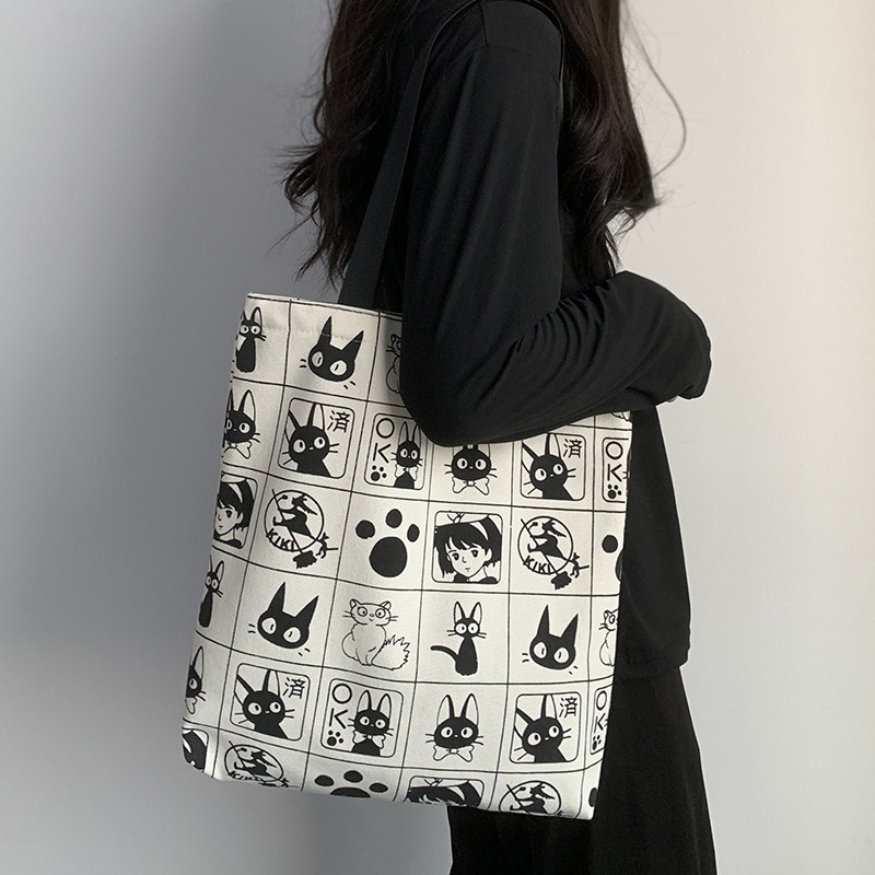 Bolsa de lona 2025 para mujer, versátil, con diseño de gato de dibujos animados, para estudiantes, con cremallera, tipo satchel.