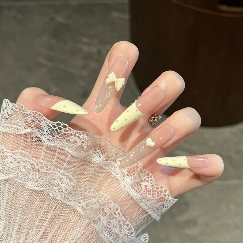 Handmade long-length wearable nail tips with cream yellow polka dots, French bow design, cat-eye effect, and a brightening effect. Finished nail tips available for wholesale Handmade long-length wearable nail tips with cream yellow polka dots, French bow design, cat-eye effect, and a brightening effect. Finished nail tips available for wholesale