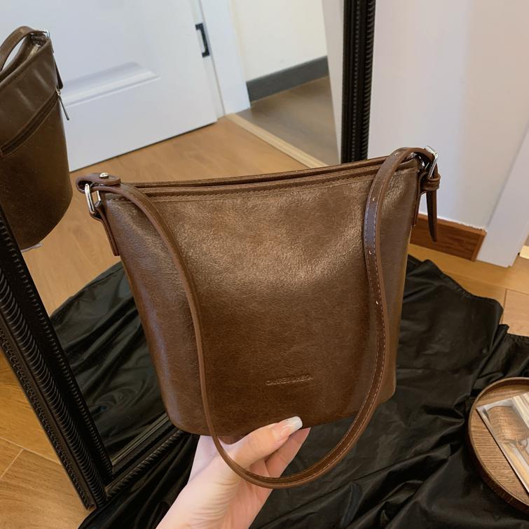 Bolsos de mano retro de alta textura para mujeres 2025, nuevos bolsos de hombro de moda simples, bolsos de cubo de transporte universal