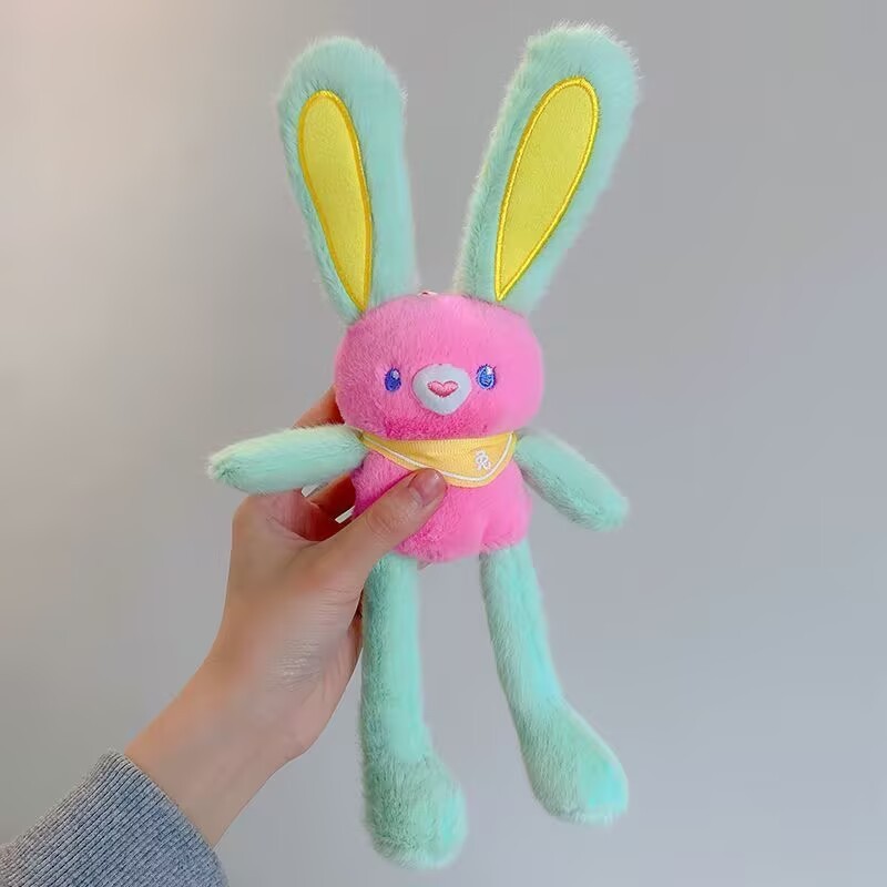 ネットの赤い耳のウサギはウサギの鍵を引いてぬいぐるみのかばんのペンダントを掛けて女の子にプレゼントします。|undefined