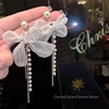 Design earrings from pearl with bow with tassels, simple and elegant design, trend of season