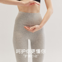 純綿の現物の女性は腰の高い中にレギンスを着ています。