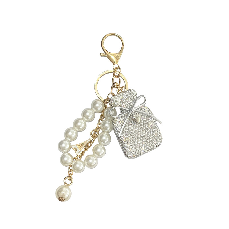 Versión coreana de la nueva botella de perfume con incrustaciones de diamantes, llavero con lazo, perla de imitación, botella de perfume de color degradado, colgante de moda