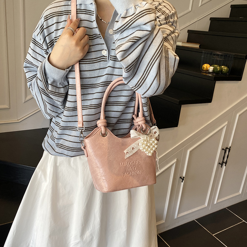 Bolso de mano de estilo occidental de ocio para mujer 2025 nuevo producto de moda de cercanías bolso de mensajero de un solo hombro de todo fósforo bolso de cubo de cuero de cera de aceite