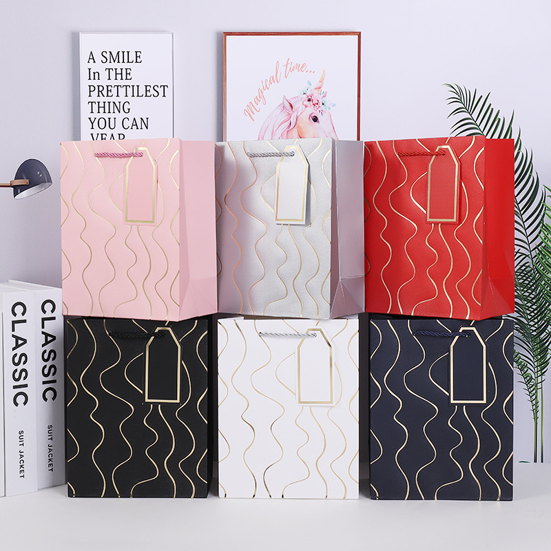 Nueva bolsa de regalo de estampado en caliente en relieve de línea ondulada, comercio exterior, bolsa de papel más vendida transfronteriza, tienda de regalos, supermercado, bolso al por mayor