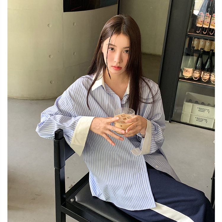 青と白のストライプは色の長袖のシャツの女性にぶつかります。