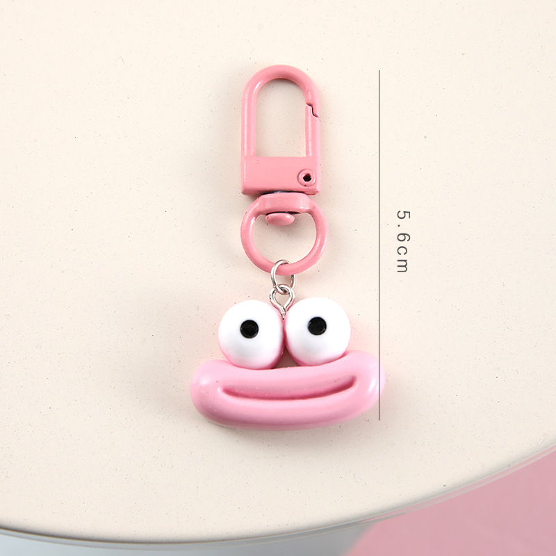 かわいいアニメの大きな口のキーホルダーは学生のカバンを飾っています。