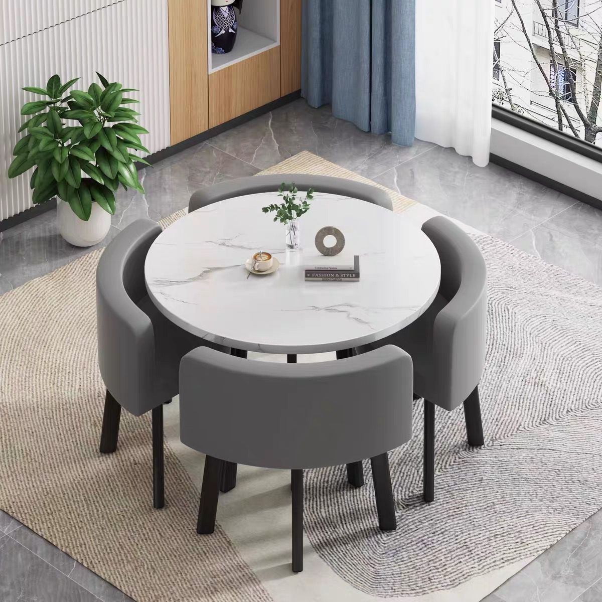 White round table + four dark gray leather chairs