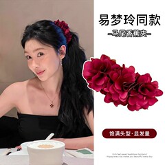 易夢玲は赤いバラのバナナを挟んで髪の量が多いです。