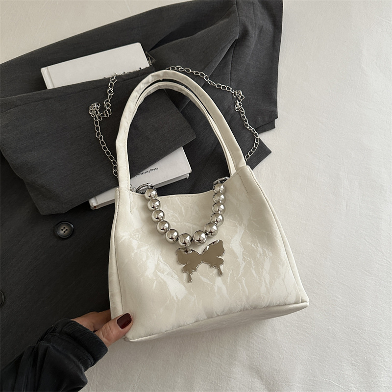 Alta sensación de lujo ligero bolso de cubo axilar 2024 verano nuevo estilo de moda arco de cuentas cadena de hombro mochila