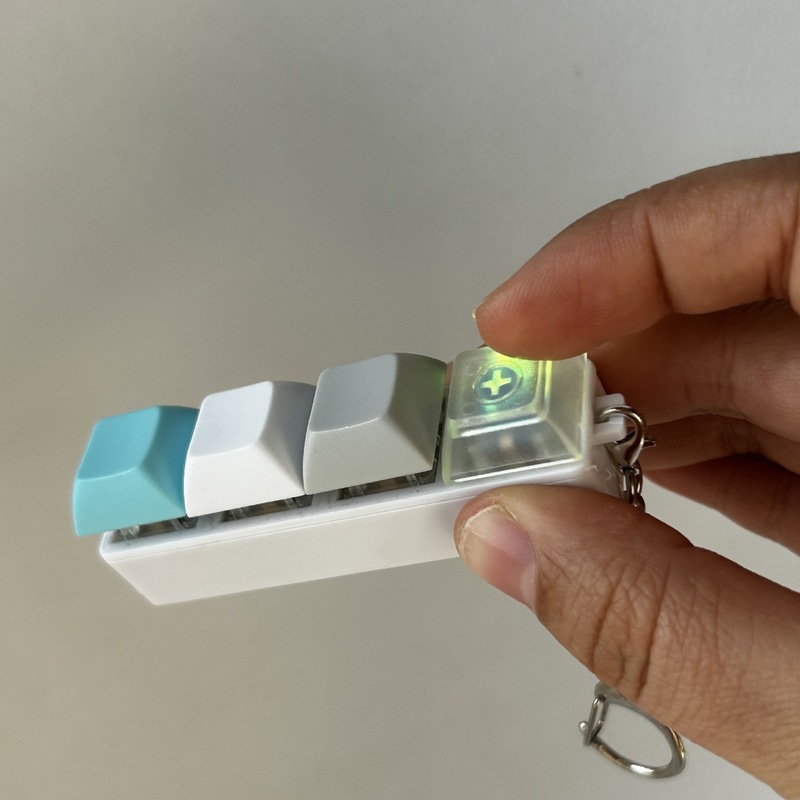 クロスボーダーカラー一字型四ボタンのキーホルダーの指先を押して解凍します。|undefined