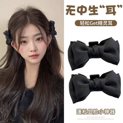 お姫様の頭の黒い頭の上の蝶結びの小さいクリップの女性の高級感の前髪のクリップのカチューシャの側のばらばらの髪の飾り