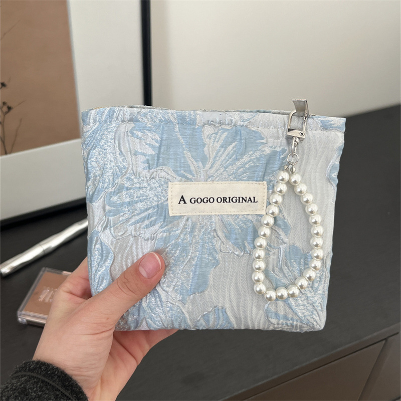 トランペットの高級感のある手は化粧バッグを持っています。布芸の財布を持っています。