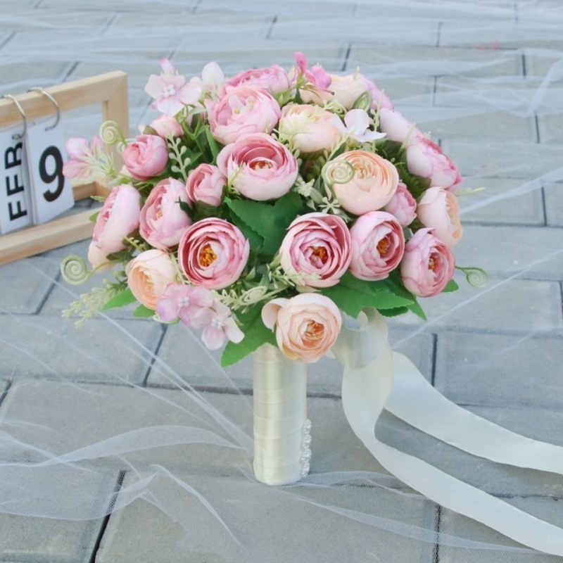 手に花を持つ新婦の韓国式結婚式の領収書のシミュレーションの花束の森系のウェディングドレスの撮影の道具の手に花をささげます。|undefined