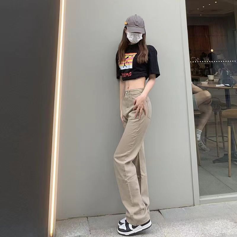 カーキ色のストレートジーンズの女性は秋冬に腰が高くてゆったりしていて、やせています。|undefined
