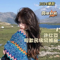 雲南麗江観光の外でニットのストールの民族風の復古のマントのマントのショールのマフラーを掛けて休暇を過ごして女性に乗ります。