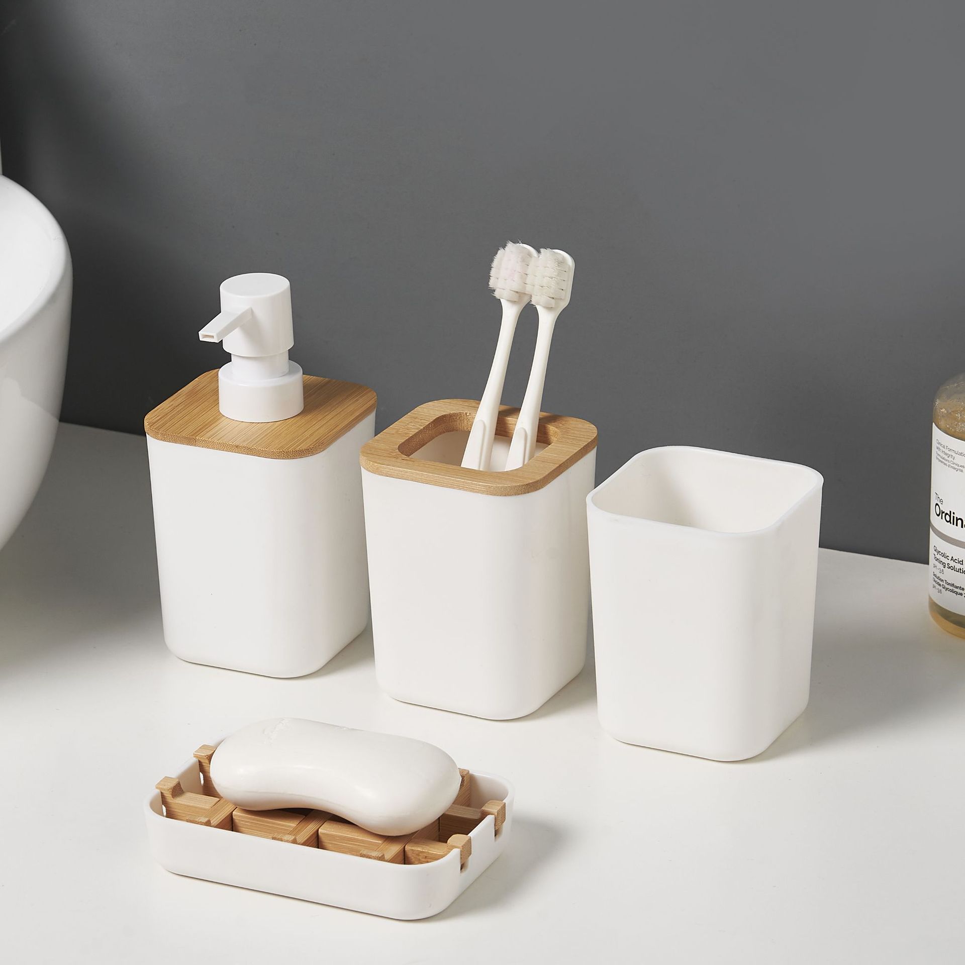 Juego de cuatro piezas de baño de bambú y madera, artículos de tocador de baño simples, soporte para cepillo de dientes, botella de loción, juego de combinación de taza de enjuague bucal