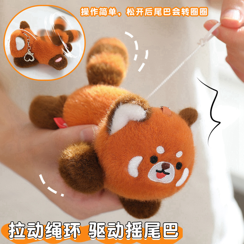 かわいいパンダの人形がしっぽを回してぬいぐるみを送って彼女のバックパックに飾っているバッグのストラップを飾っているぬいぐるみ|undefined