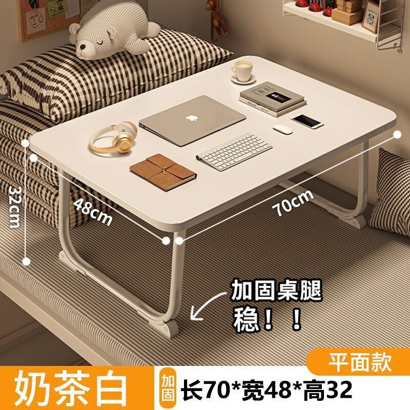 ベッドの上の小さい机のノートパソコンの机の上で折り畳みます。|undefined