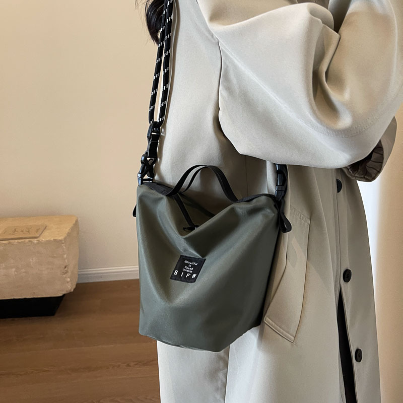 休閒簡約水桶包2024新款潮流大容量單肩包男情侶運動手機斜挎包