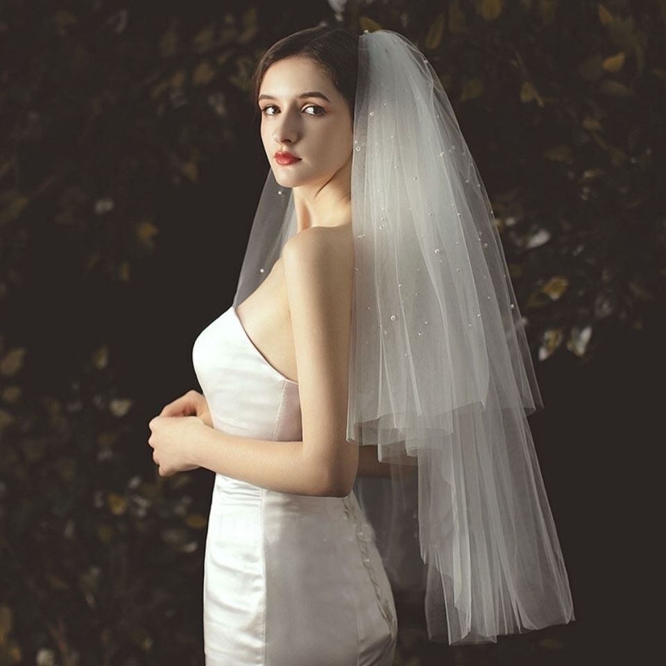 Multi-layered, individually wrapped, fluffy, minimalist veil in off-white with crystal accents, rolled edges, and pearl detailing&mdash;long, elegant white double-layered design.